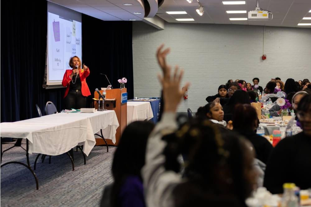 Girls of Color Summit previous event a speaker pointing at a participant raising her hand